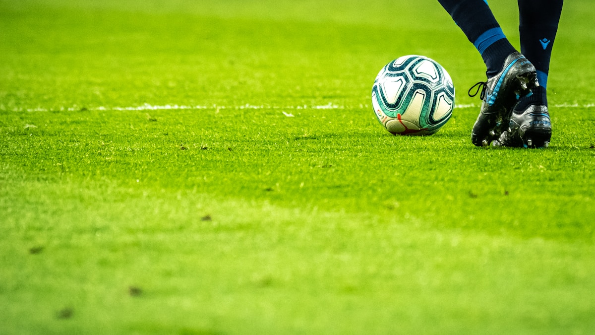 Soccer player celebrating on a floodlit stadium pitch